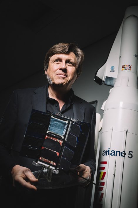 Astronaut Ulrich Walter stehend vor einem Ariane Raketenmodel.