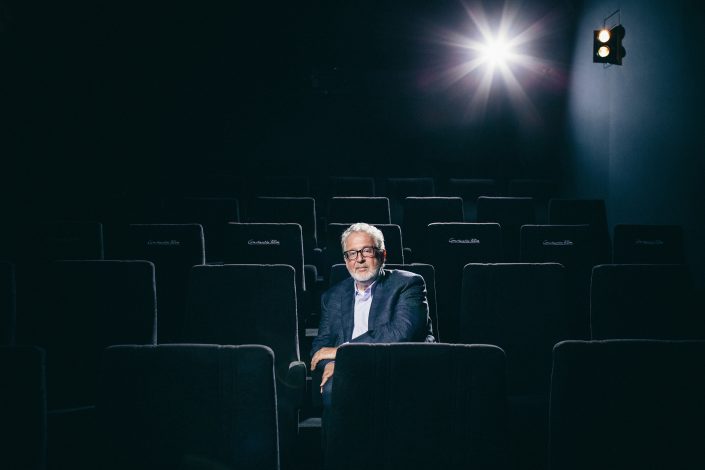 Martin Moszkowicz sitzend im schwarzen Kinosessel des hauseigenen Kinosaals.