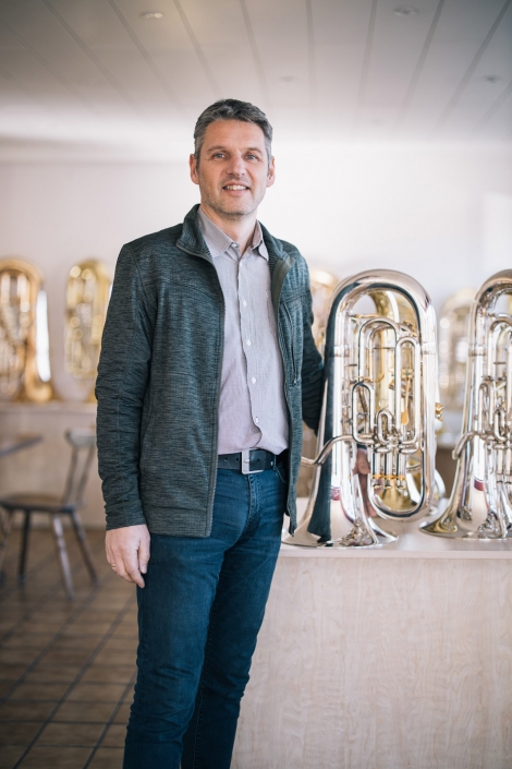 Christian Niedermaier steht im Showroom neben einer silberfarbenen Tuba.